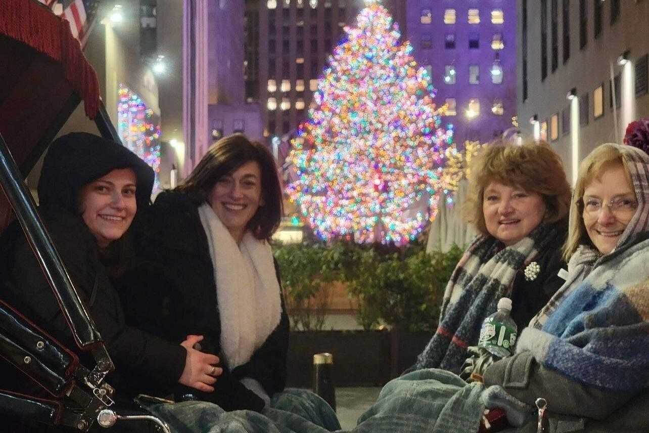 4 donne in una carrozza con l'albero di Natale del Rockefeller Center sullo sfondo